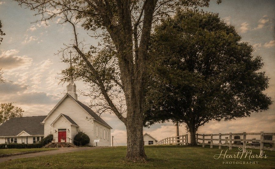 A white country church glowing in golden hour light